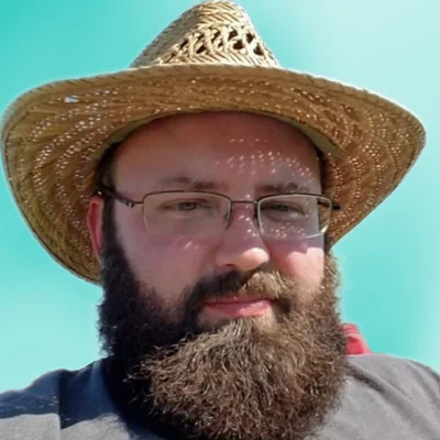 Tim Morgan, wearing a straw hat and glasses