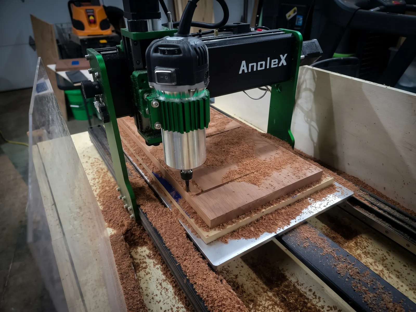 Close-up of the machine cutting a wooden board, surrounded by wood chips.